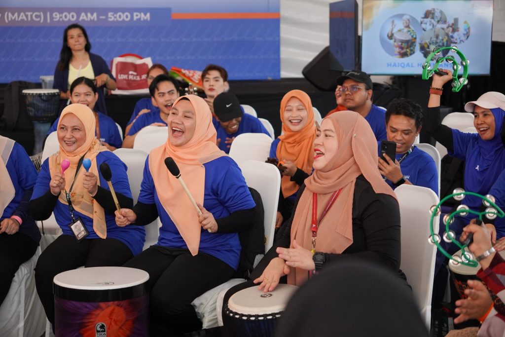 Participants playing drums and shakers in a team building session