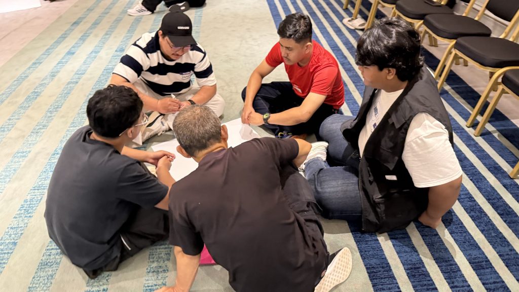 Participants seated on the floor working on a task together