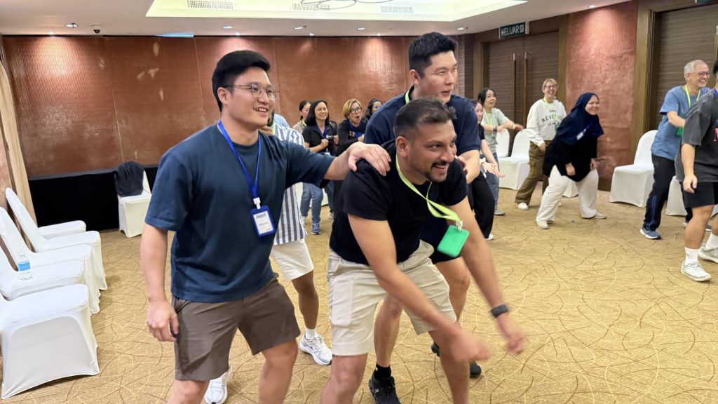 Participants laughing during a group activity in a hotel function room