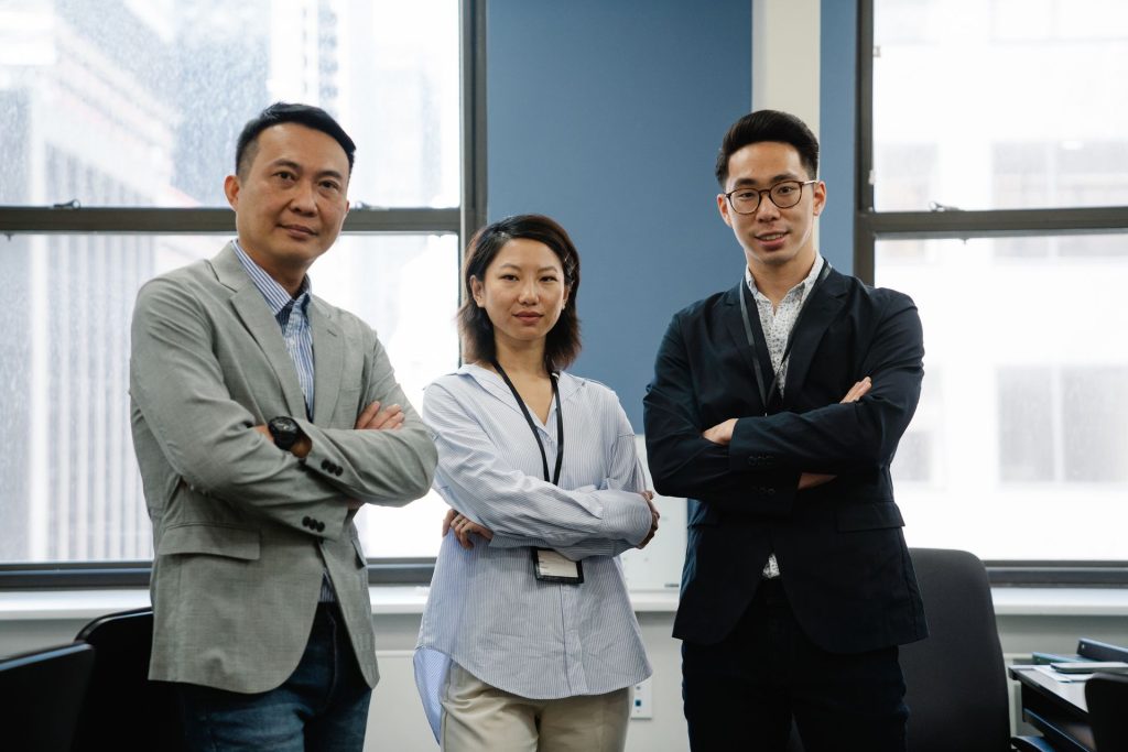 Three managers standing with arms crossed in an office